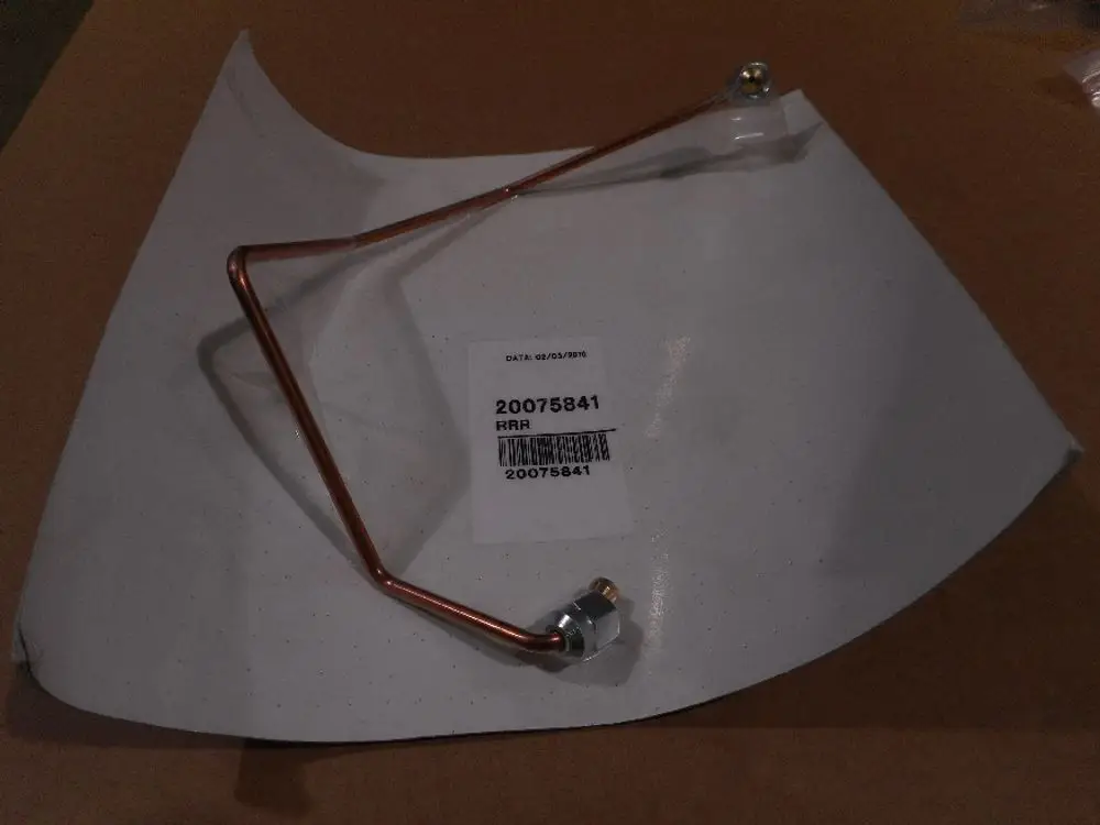 Remeha Ölröhrchen aus Kupfer, in gebogener Form mit einer Metallanschlussmutter. Liegt auf einem weißen Blatt Papier mit Produktlabel.